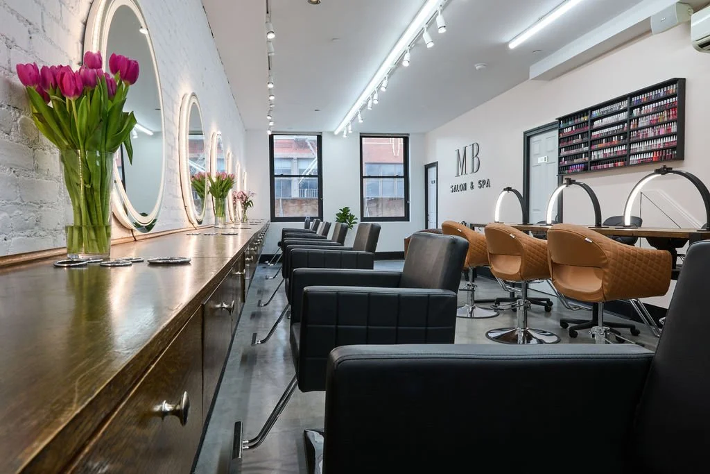 Interior do Maria Bonita Salon & Spa com espelhos, bancadas e cadeiras de atendimento