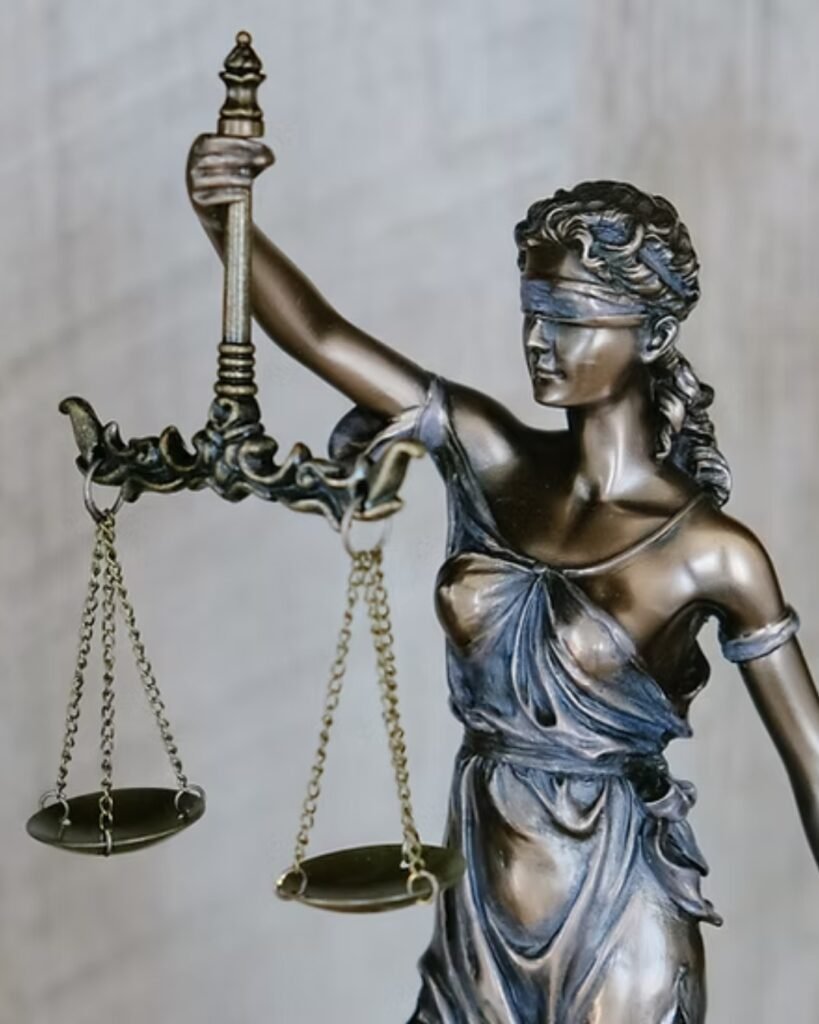 Estátua de uma mulher vendada segurando uma espada e uma balança, símbolo da justiça
