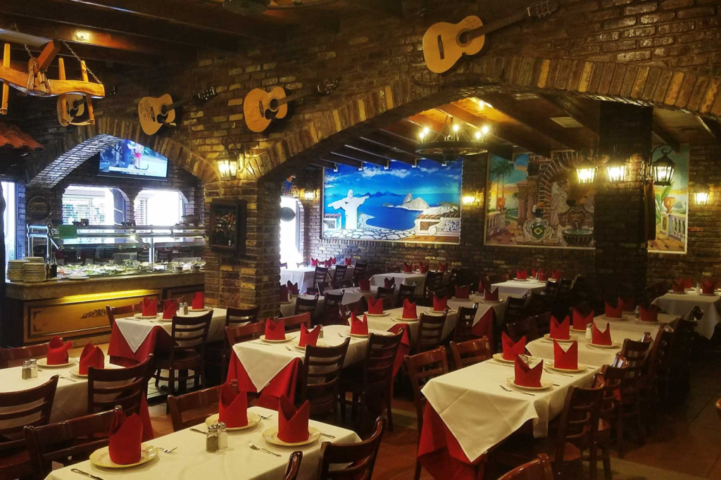 Salão interno do Boi na Brasa em Newark, com mesas preparadas e decoração brasileira.