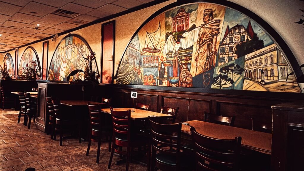 Salão da Brasilia Grill com mesas e mural inspirado no Brasil