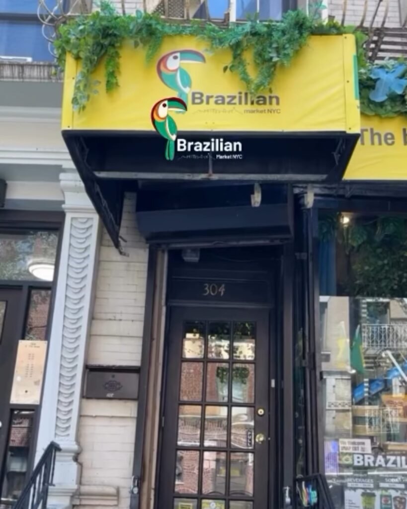 Fachada da Brazilian Market NYC, com letreiro amarelo, tucanos ilustrados e entrada no número 304