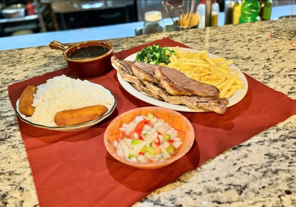 Prato de picanha com arroz, batata frita, vinagrete e acompanhamentos no Rei da Picanha